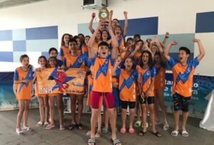 El Club Natación Huelva levantando el trofeo tras su gran éxito. / Foto: @CNHUELVA.