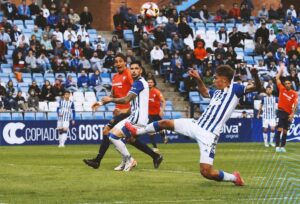 De la Rosa está cerca de marcar tras un balón que en principio no pudo rematar Caye Quintana. / Foto: @recreoficial.