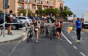 Algunas participantes acabando el segmento de ciclismo para iniciar el de carrera a pie.