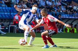 Dani Perejón, con un vendaje en la cabeza tras recibir un golpe en los primeros compases, intentando iniciar una jugada. / Foto: @recreoficial.