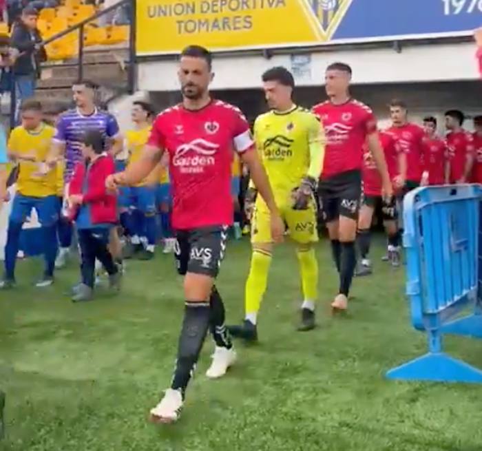 Los equipos saltando al terreno de juego para la disputa del partido entre el Tomares y el Cartaya. / Foto: Captura imagen @AD_Cartaya.